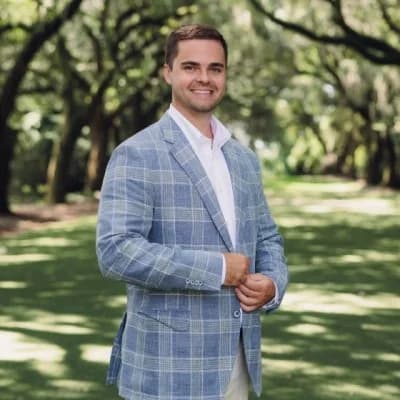 Collin Wohlfert, standing outdoors in a light blue checked blazer